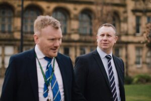 Two people in suits walking 