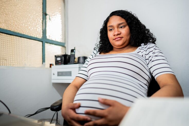 Pregnant woman sitting down.