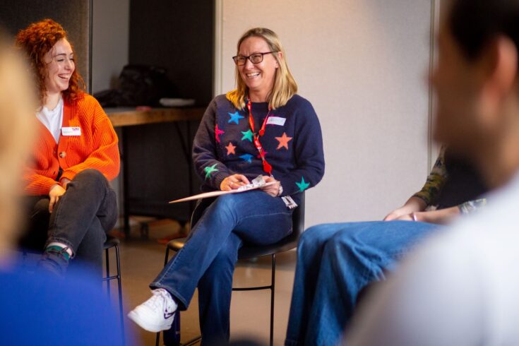 People sitting on chairs and smiling at each other