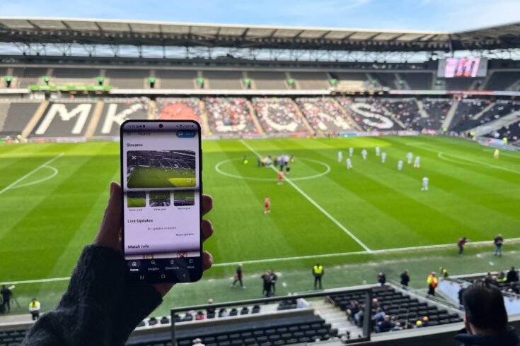Smart phone streaming football content at the same time as user watching a football match at Stadium MK