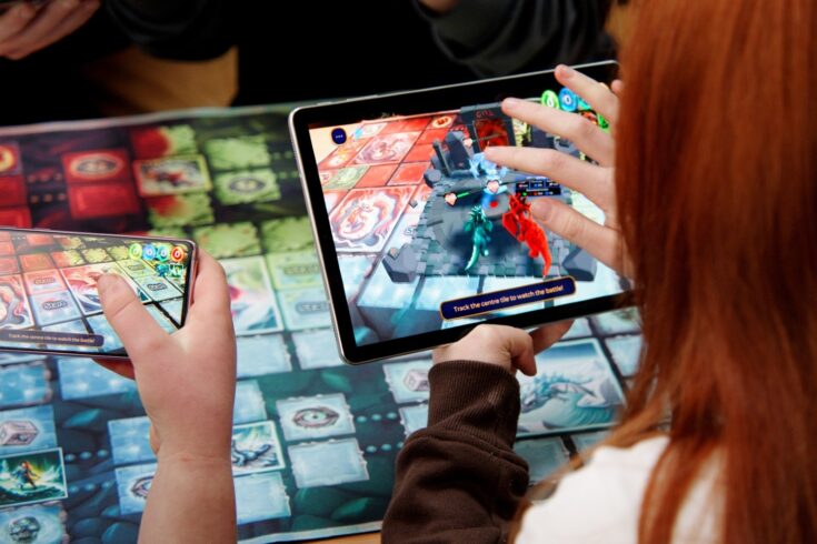 Two people looking at gaming devices.