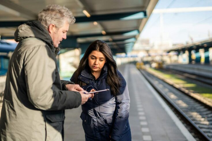Two people standing on a platform, completing a survey.