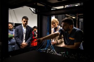 A group of delegates being shown a piece of technology.