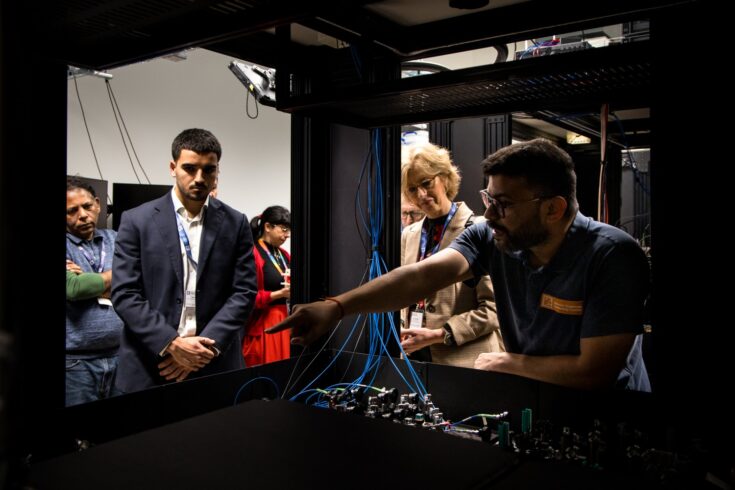 A group of delegates being shown a piece of technology.