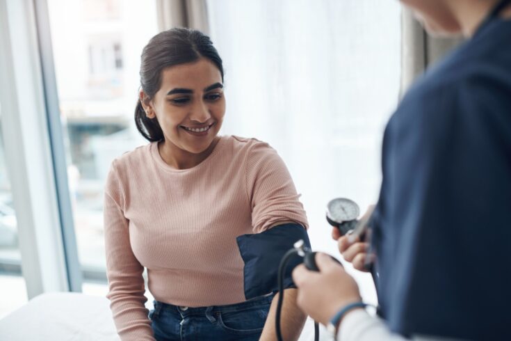 A doctor checking a patient's blood pressure.