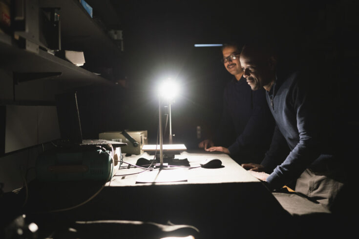 Two male researchers observing a light in a lab.