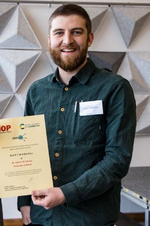 A man wearing a green shirt holding a certificate