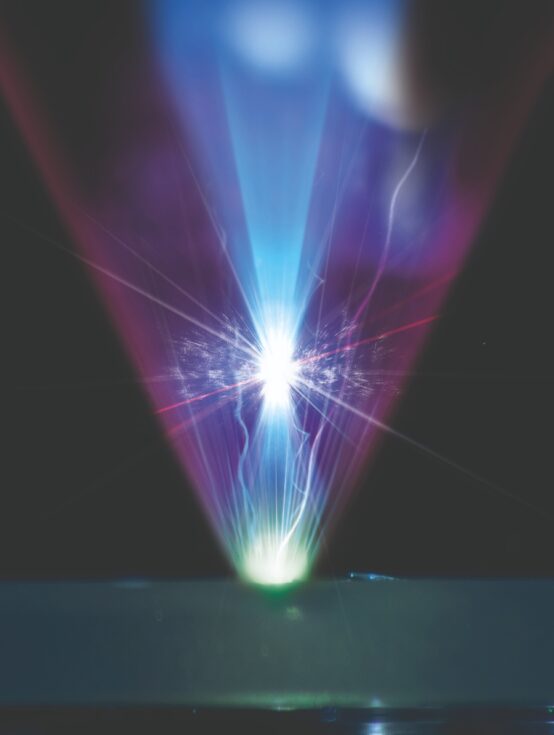 Coherent harmonic focus (CHF) generation. The laser is focused on a target, the reflected purple beam forms a CHF of extreme intensity that generates matter from light. Photos of the interaction are combined with an artist’s interpretation of the CHF.
