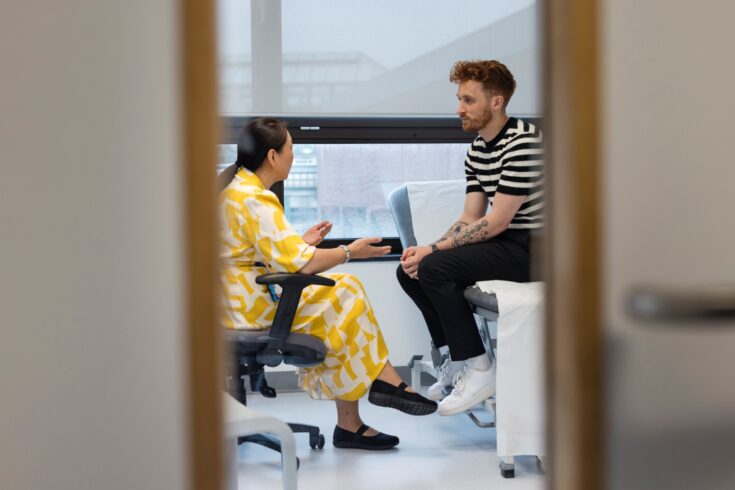 A wide angle view a young man who is visiting his GP for a consultation and some advice about an ailment.