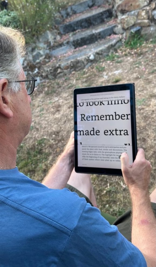 Andrew using a reading device to magnify text.