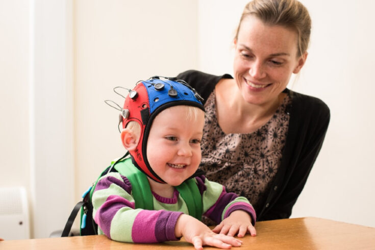 Woman and child. The child is wearing an electroencephalogram cap, which can be used to measure ‘brain waves’