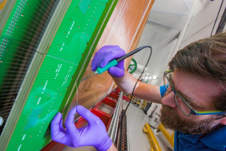 A man working on an Anode Plane Assembly at Daresbury Laboratory.